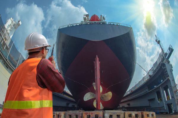 supervisor, foreman, inspector, surveyor takes final inspection of the cleaning, repairing, recondition of over hull of the commercial ship in dry dock yard, ready to delivery the ship to the sea